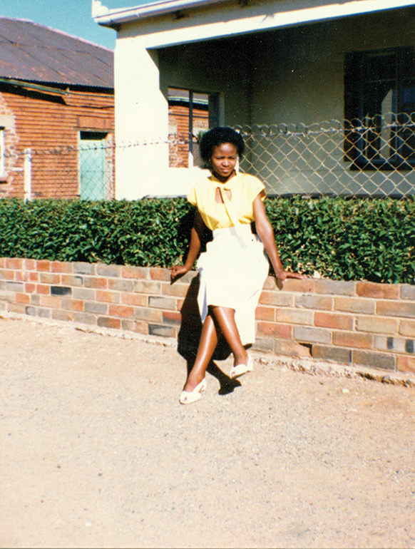 Virginia-Segoe-in-her-early-twenties-next-to-the-clipped-hedge