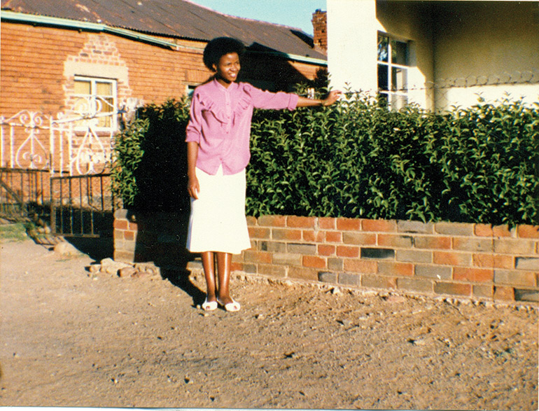 Virginia-Segoe-in-her-twenties-next-to-the-clipped-hedge